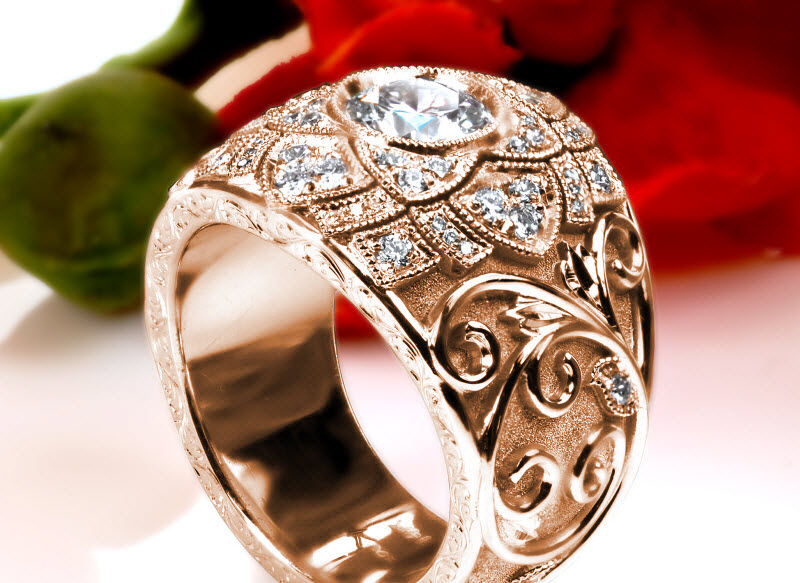 Custom wide band rose gold engagement ring in Milwaukee with a diamond set center floral design and hand engraved vine patterns.
