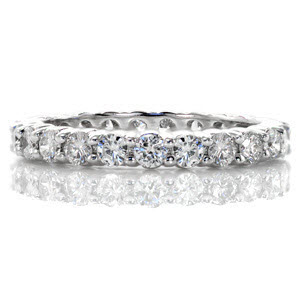 This sophisticated eternity band features a total of 1.44 carats of round brilliant cut diamonds. The stones are set with elegant, shared prong settings which minimize the amount of the diamond being covered by metal prongs. This design has a low profile and can be worn as a wedding or anniversary band.