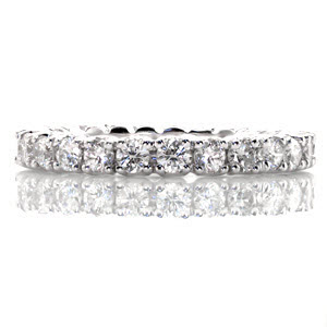This graceful eternity band features a continuous row of round brilliant stones in four prong settings. The side profile reveals open sided settings that create a flowing, visual appeal. The ring totals 1.30 carats of vividly brilliant diamonds that will create a beautiful display in all light.
