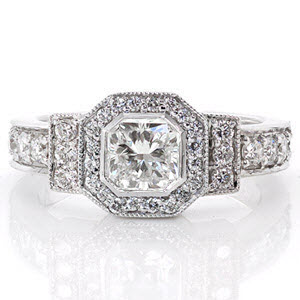 A charming ring featuring a 0.75 carat square radiant cut center diamond set into a bezel, this design is sure to dazzle. The smooth edge of the bezel setting contrast with the milgrain edges of the halo and side bars to help highlight the center stone. The design is detailed with micro pavé.