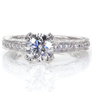 This classic design features a 1.00 carat round brilliant. Side stones along the top of the band capture the same radiance as the center diamond. Exquisite hand engraving and filigree give this design a timeless appeal. A row of micro pavé on the basket and prongs of the round center add a surprising detail. 