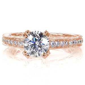 This classic design features a 1.00 carat round brilliant. Side stones along the top of the band capture the same radiance as the center diamond. Exquisite hand engraving and filigree give this design a timeless appeal. A row of micro pavé on the basket and prongs of the round center add a surprising detail. 
