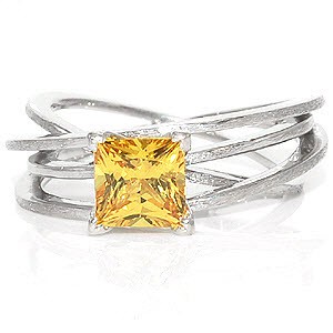 Design 1168 elegantly displays a 1.25 carat princess cut sapphire within four v-shaped prongs. Crafted in 14k white gold, the height of the multiple bands give the appearance of movement. The flow of the bands add interest which intensifies the vibrant hue of the natural yellow sapphire.