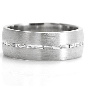 Design 1169 is a sophisticated band crafted in 14k white gold. The wide presence of the band forms into a low profile for a tailored fit. A single row of channel set baguettes are horizontally set down the center. The brushed finish to the bands surface highlights the eternity row of diamonds.