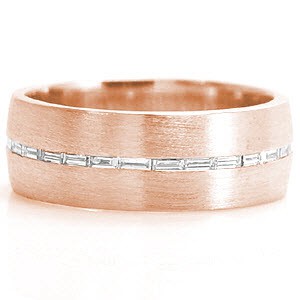 Design 1169 is a sophisticated band crafted in 14k white gold. The wide presence of the band forms into a low profile for a tailored fit. A single row of channel set baguettes are horizontally set down the center. The brushed finish to the bands surface highlights the eternity row of diamonds.