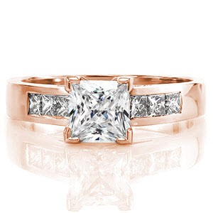 The clean lines of the Princess Cathedral design showcases a pristine 1.00 carat princess cut center diamond. Adding sparkle to the 14k white gold band are channel set princess cut diamonds. The graceful shoulders angle towards the center for a contemporary style.