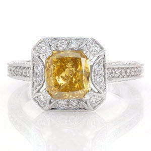 A mesmerizing ring shown with a 1.50 carat yellow cushion cut diamond. This alluring stone is set in a unique halo with a star burst cut-out around the center stone. Under the halo is detailed with unique cut-outs. All the exquisite elements in this ring, are adorned in micro pavé.