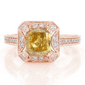 A mesmerizing ring shown with a 1.50 carat yellow cushion cut diamond. This alluring stone is set in a unique halo with a star burst cut-out around the center stone. Under the halo is detailed with unique cut-outs. All the exquisite elements in this ring, are adorned in micro pavé.