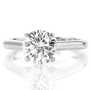 Tangiers is a modern solitaire design featuring 1.50 carat round brilliant. The straight uniform lines of the cathedral are fashioned just below the side of the diamond. The height of the mounting showcases the center stone for a refined statement. The 14k white gold metal shines from the high-polished finish. 