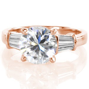 The magnificent Limon design puts all the focus on the stunning 2.50 carat round brilliant cut diamond. The band is elegantly detailed with a pair of baguette cut diamonds on each side of the center. The step-cut side stones draw the eye in from the lustrous metal ring towards the middle. This is a truly regal piece.