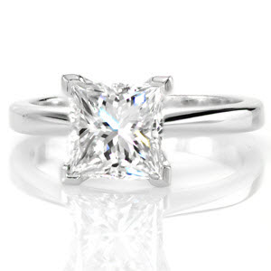 The Princess Classic Solitaire proudly displays a 1.50 carat diamond. Raised high above the mounting for an impressive statement this diamond takes center stage. V-tip prongs protect the edges of the square stone and lends a decorative detail. Pinched shoulders adds contour and dimension to the band.  