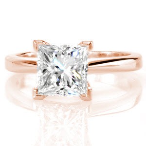 The Princess Classic Solitaire proudly displays a 1.50 carat diamond. Raised high above the mounting for an impressive statement this diamond takes center stage. V-tip prongs protect the edges of the square stone and lends a decorative detail. Pinched shoulders adds contour and dimension to the band.  