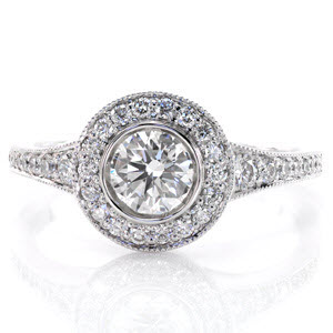 This elegant design is beautifully appointed with a bezel set, 0.75 carat round brilliant cut center diamond which is surrounded by a micro pavé halo. The smooth, uninterrupted lines of the ring are created by the reverse taper of the band. The edges detailed in milgrain add a refined texture.