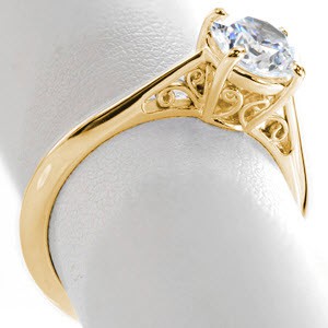 Unique yellow gold engagement rings in Baton Rouge. This elegant solitaire engagment ring has antique style inspirations shown by the expertly hand crafted filigree curls set in the basket and tapered band. 