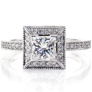 The 0.75 carat princess cut diamond is harmonious to the square shaped halo that surrounds it. The defined lines of this halo accentuates the size of the center stone it secures. micro pavé diamonds adorn this ring from the top and side of the halo as well as the length of the band.