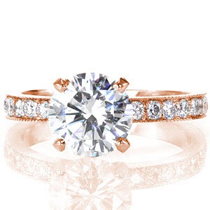 For an heirloom-quality classic style, look no further than the Pave Design. This exquisite piece features a 1.50 carat round brilliant center diamond set in a four prong crown. The band has simple, pleasing lines and micro pavé diamond detail. The edges of the band are detailed with milgrain.