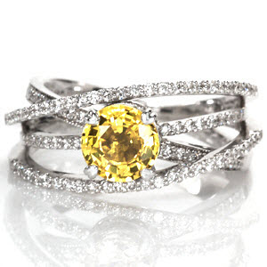 Design 1510 displays a mesmerizing sense of movement with four micro pavé bands. The height of the different bands create a perfect pocket for a unique 1.25 round yellow sapphire. The 14k white gold band wraps the natural sapphire in two micro pavé halos and is secured in a four prong basket.