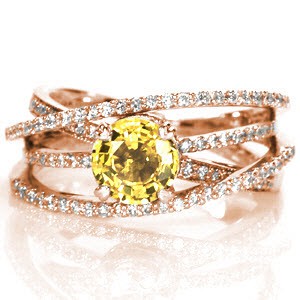 Design 1510 displays a mesmerizing sense of movement with four micro pavé bands. The height of the different bands create a perfect pocket for a unique 1.25 round yellow sapphire. The 14k white gold band wraps the natural sapphire in two micro pavé halos and is secured in a four prong basket.