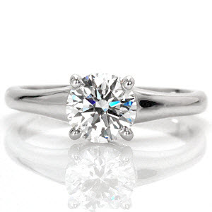 Flare Solitaire is a captivating 1.00 carat round brilliant contemporary engagement ring. The band widens to the top of the ring placing emphasis on the enthralling center stone. The smooth finish of the polished band magnifies the fire and luster of the diamond.