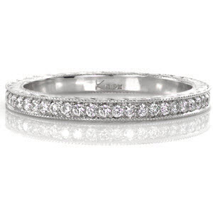 This classic eternity band features elegant details flowing around the entire ring for a seamless finish . The top of the band is bead set with micro pavé diamonds that sparkle vibrantly. The two sides are hand engraved with a half-wheat pattern that captures light in the bright cuts for added dimension. 