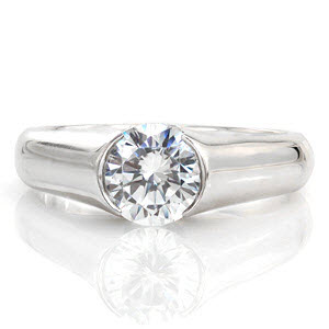 Luna is a high-polished contemporary design featuring a 1.0 carat diamond. The smooth finish of the band heightens the brilliance of the center stone. Raised shoulders extend in a cathedral to the top of the diamond. The open half-bezel displays the lovely silhouette of the round diamond for a picturesque view.  