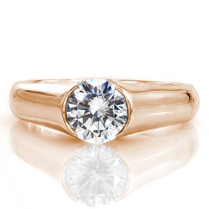 Luna is a high-polished contemporary design featuring a 1.0 carat diamond. The smooth finish of the band heightens the brilliance of the center stone. Raised shoulders extend in a cathedral to the top of the diamond. The open half-bezel displays the lovely silhouette of the round diamond for a picturesque view.  