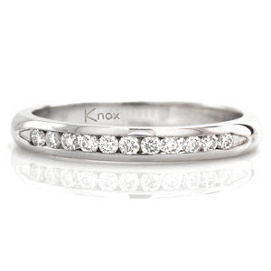 The Petite Channel band features 11 round brilliant diamonds totaling .18 carats. Channel set along the length of the ring the stones are positioned next to each other for a seamless look. A smooth finish enhances the brilliance and luster in the row of diamonds adding to its timeless appeal. 