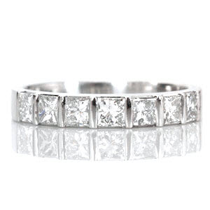 Design 1540 features 7 half-bezel set princess cut diamonds totaling 0.80 carats. Each square stone is fashioned in a single row along the band and is evenly spaced between a bar of metal. This high polished band pairs beautifully with a princess cut solitaire or by itself for a modern right hand ring.