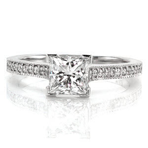 This charming design has a classic feel with the modern touch of a 1.00 carat princess cut center diamond. Chevron prongs are used to protect the corners of the princess cut. The micro pavé on the band goes all the way up the the sides of the cathedral setting to the edges of the center stone. 