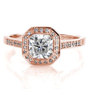 The bold lines of the bezel frames the unique shape of the 1.00 carat radiant cut center. Mimicking the body of the radiant, micro pavé stones contour in a halo of a similar silhouette. Surprise diamonds on each side of the band adds a delightful charm to the side-profile of this design.    