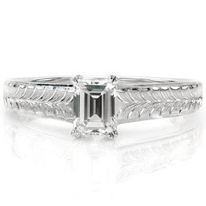The hand engraved wheat pattern along the top of the band draws the eye to the linear lines of the step-cut center stone. A double prong around each clipped corner of the 0.65 carat emerald cut securely fashions the diamond. The polished sides adds a sleek appeal to this vintage inspired design.   