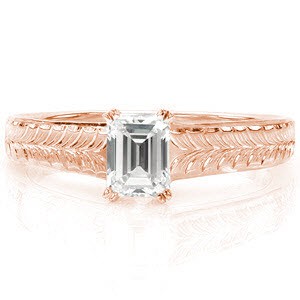The hand engraved wheat pattern along the top of the band draws the eye to the linear lines of the step-cut center stone. A double prong around each clipped corner of the 0.65 carat emerald cut securely fashions the diamond. The polished sides adds a sleek appeal to this vintage inspired design.   