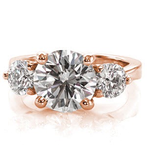 This stunning design is features a 2.20 carat round brilliant cut diamond. The center stone, and two side stones are set in interwoven, trellis patterned prong settings. The graceful curves of the setting, and the reverse tapered band create an elegant ring.