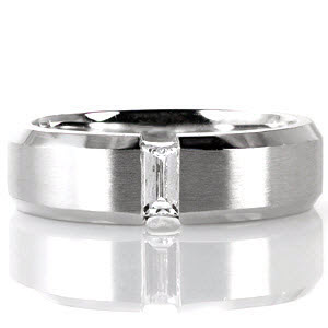 Crafted in 14k white gold, design 1636 has a modern presence and refined lines. The center of the band has a brushed finish that holds a center baguette diamond totaling 0.23 carats. Highlighting the center stone, beveled edges merge and hold the channel set diamond for added intriguing.  