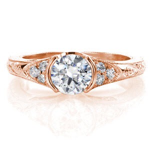 This is a vintage-inspired design that uses intricate details to accent the 0.75 carat round brilliant diamond. The center stone is bordered by a small triangular array of side stones for added embellishment. The exquisite handmade filigree and hand engraving gives it that heirloom-quality finish. 