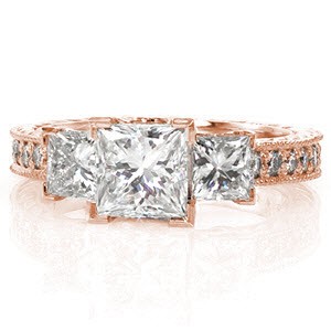 The Rachel combines the classic style of a three stone with the contemporary shape of a princess cut. Each square diamond is set in chevron prongs to protect the corners. The top of the band is detailed round micro pavé diamonds and edged in milgrain texture for a refined finish.