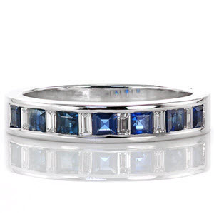 This ring mesmerizes with its blue sapphire princess cut stones. The sapphires alternate with baguette cut diamonds which tie beautifully with the 14k white gold. The straight lines are carried throughout the design of the band for simple elegance. The cool tone of the stones and metal make for a sticking statement. 
