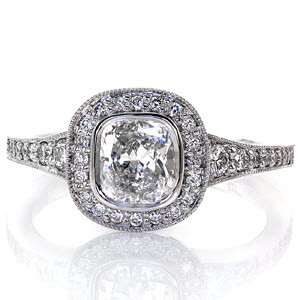 Graceful rounded edges of the micro pavé halo accentuate the cushion cut brilliant center. The bright white luster of the polished sides compliment the bezel securely fashioning the 1.00 carat cushion. Diamonds graduate in size as the band flares to the top of the ring for a magnificent top view.