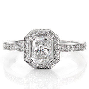 The modern lines of the full bezel envelop the 0.75 carat radiant diamond in streamlined sophistication. The octagonal shaped halo and band radiates with micro pavé accents and milgrain edging. The design proudly displays the center stone culet and smartly allows space for a band to sit flush.