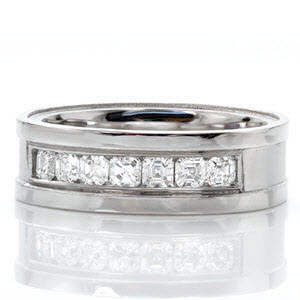 The Denali design is a sophisticated wedding band featuring seven small asscher cut diamonds in a channel setting. The middle of the band has a sandblasted finish and the wide rails are given a high polish. This contrast helps to highlight the 0.68 total carats of diamonds.