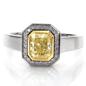 The classic Art Deco era is the inspiration behind the Heidi design. The 1.00 carat fancy yellow radiant cut center diamond is accented by a 14k yellow gold bezel and then wrapped in a 14k white gold halo of hand set micro pavé diamonds and a wide high polish band designed for comfort.