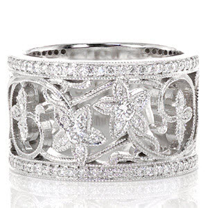 The Lily design captures a field of wildflowers with refinement and elegance. Two micro pavé rows of diamonds frame a menagerie of 14k white gold vines with three and five petal blooms. Delicate hand applied milgrain adorns every edge of this wide heirloom band.