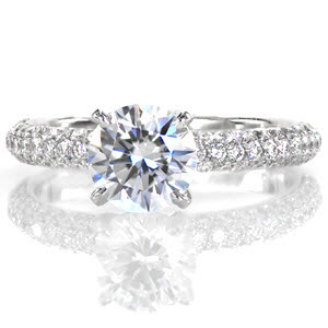 Sonata is a classic and sophisticated ring. A delicate four prong crown holds a 1.0 carat round brilliant diamond. The three rows of micro pavé diamonds along the band add tremendous radiance when the light reflects along the stones. The band has a round comfort fit profile for additional softness.