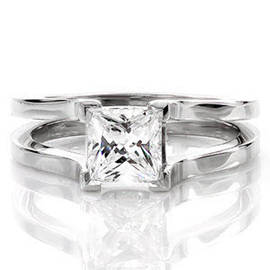 The Cathedral design has four chevron prongs that frame a 1.00 carat princess cut diamond solitaire. The shank swoops upwards towards the stone showcasing the side view of the diamond. The crisp split shank band in 14k white gold creates a modern look for this contemporary design.