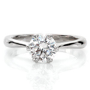 Verona is an exquisite solitaire displaying a 1.0 carat round brilliant. The six V-shaped prongs are fashioned next to each other to form sets of double prongs. This decorative feature blends seamlessly into the reverse tapered band. The high-polished finish heightens the luster of the brilliant center.  