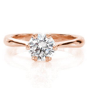 Verona is an exquisite solitaire displaying a 1.0 carat round brilliant. The six V-shaped prongs are fashioned next to each other to form sets of double prongs. This decorative feature blends seamlessly into the reverse tapered band. The high-polished finish heightens the luster of the brilliant center.  