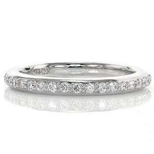 This classic wedding band is designed to match the Round Halo Engagement Ring but can be paired with a variety of other ring styles. Brilliantly cut stones are bead-set in a single row across the top of the band. Stones go halfway around the band leaving smooth, high polished sides along the remainder of the design. 