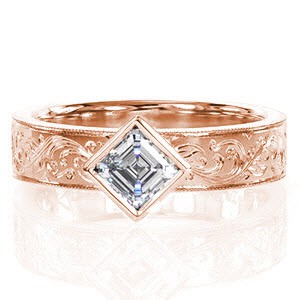 Custom rose gold engagement ring in Charleston with a bezel kite set asscher cut center diamond paired with a hand engraved scroll patterned band.