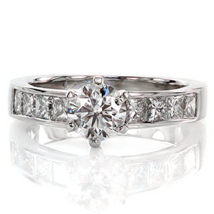 The antique style six prong setting securely fashions the 0.80 carat round brilliant diamond. Channel set princess cut side diamonds lend a stylish contrast to the stunning center stone. The Euro-shank offers a comfortable fit and prevents the ring from spinning. 