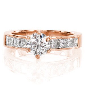 The antique style six prong setting securely fashions the 0.80 carat round brilliant diamond. Channel set princess cut side diamonds lend a stylish contrast to the stunning center stone. The Euro-shank offers a comfortable fit and prevents the ring from spinning. 